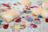 A colorful assortment of mystery bundle squishies arranged on a mint green surface with sparkles.