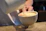 Barista preparing a cup of coffee with latte art in a cozy café setting.