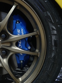 a close up of a blue brake pad on a yellow sports car