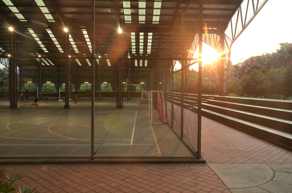 a tennis court with a sun setting behind it