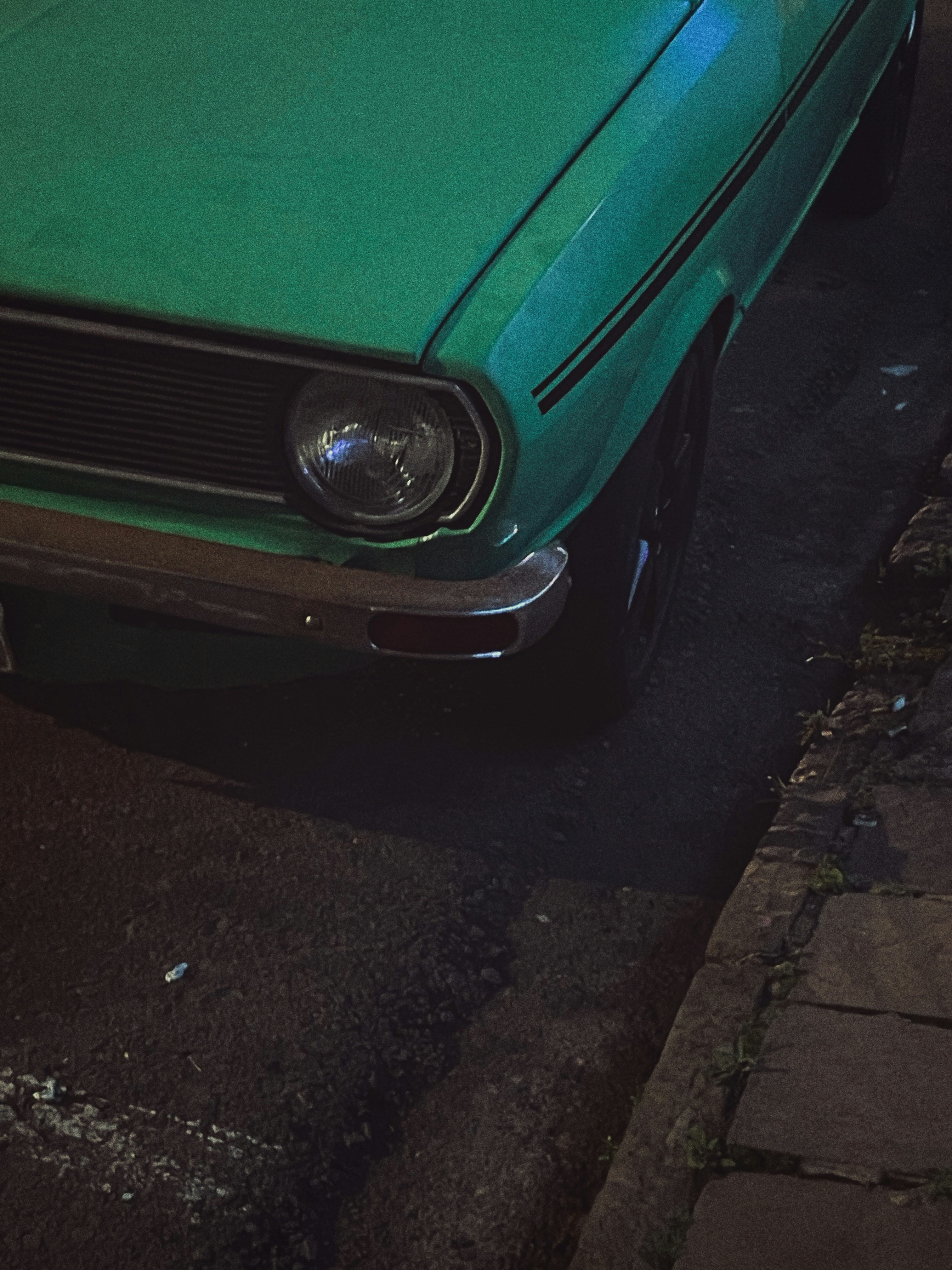 a green car parked on the side of the road