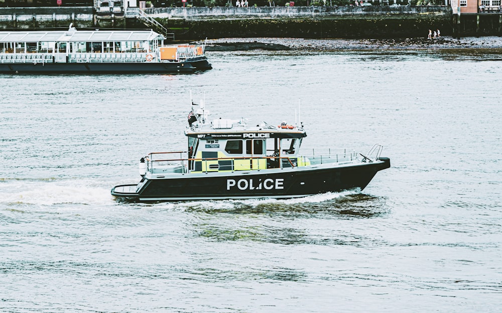 a police boat traveling down a river next to a dock