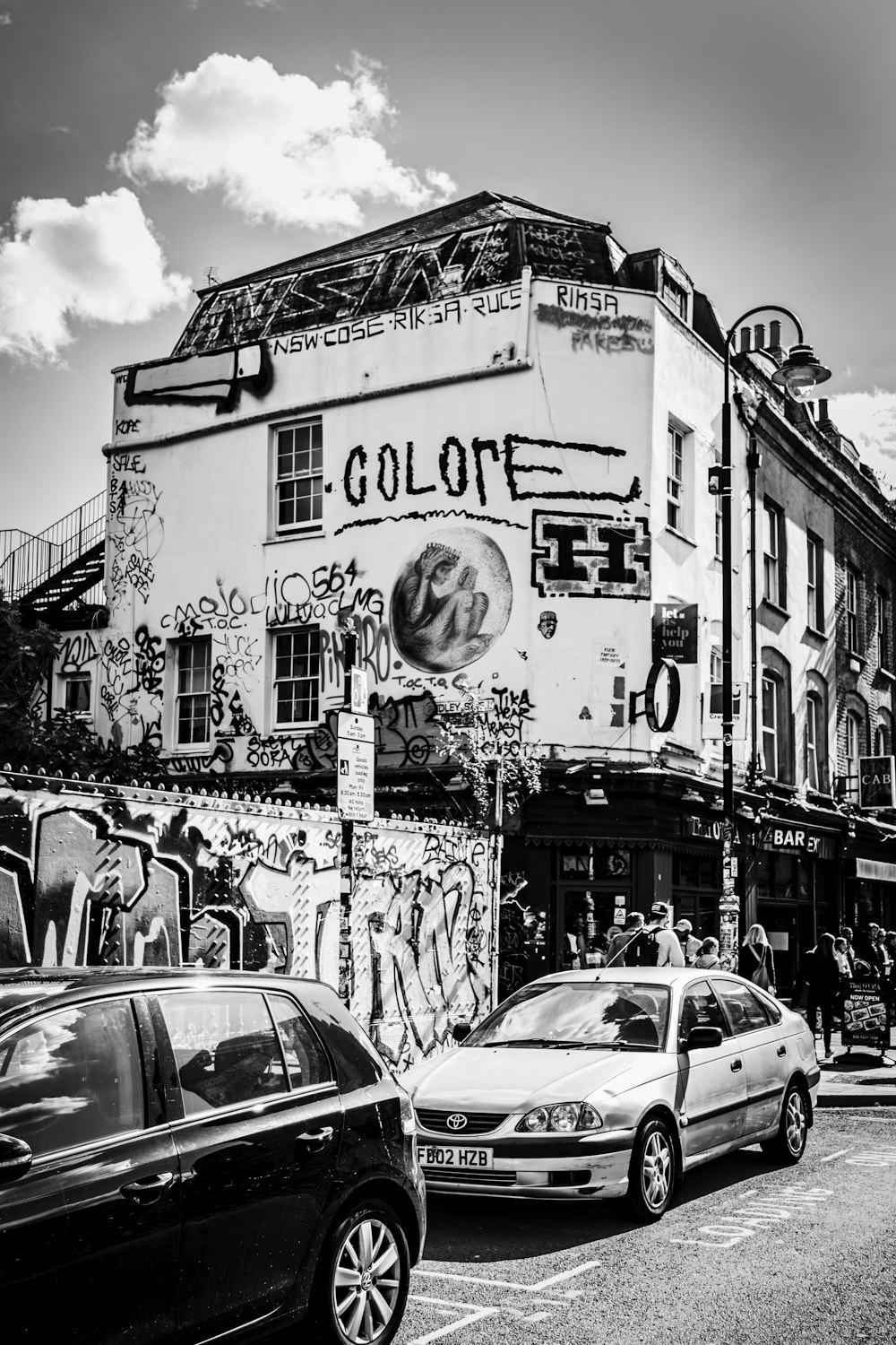 a black and white photo of cars parked in front of a building