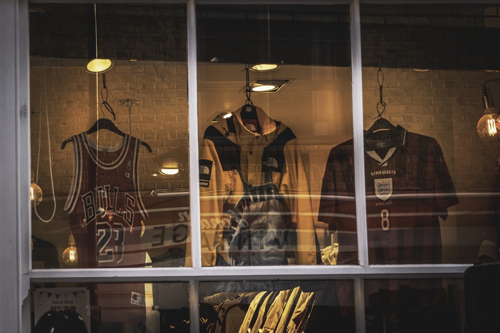 una ventana con un montón de camisetas deportivas en ella