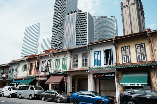 A row of modern shophouses in Bogor with landscaped surroundings and vibrant community activity.