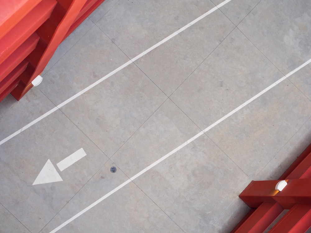 a red bench sitting on top of a cement floor