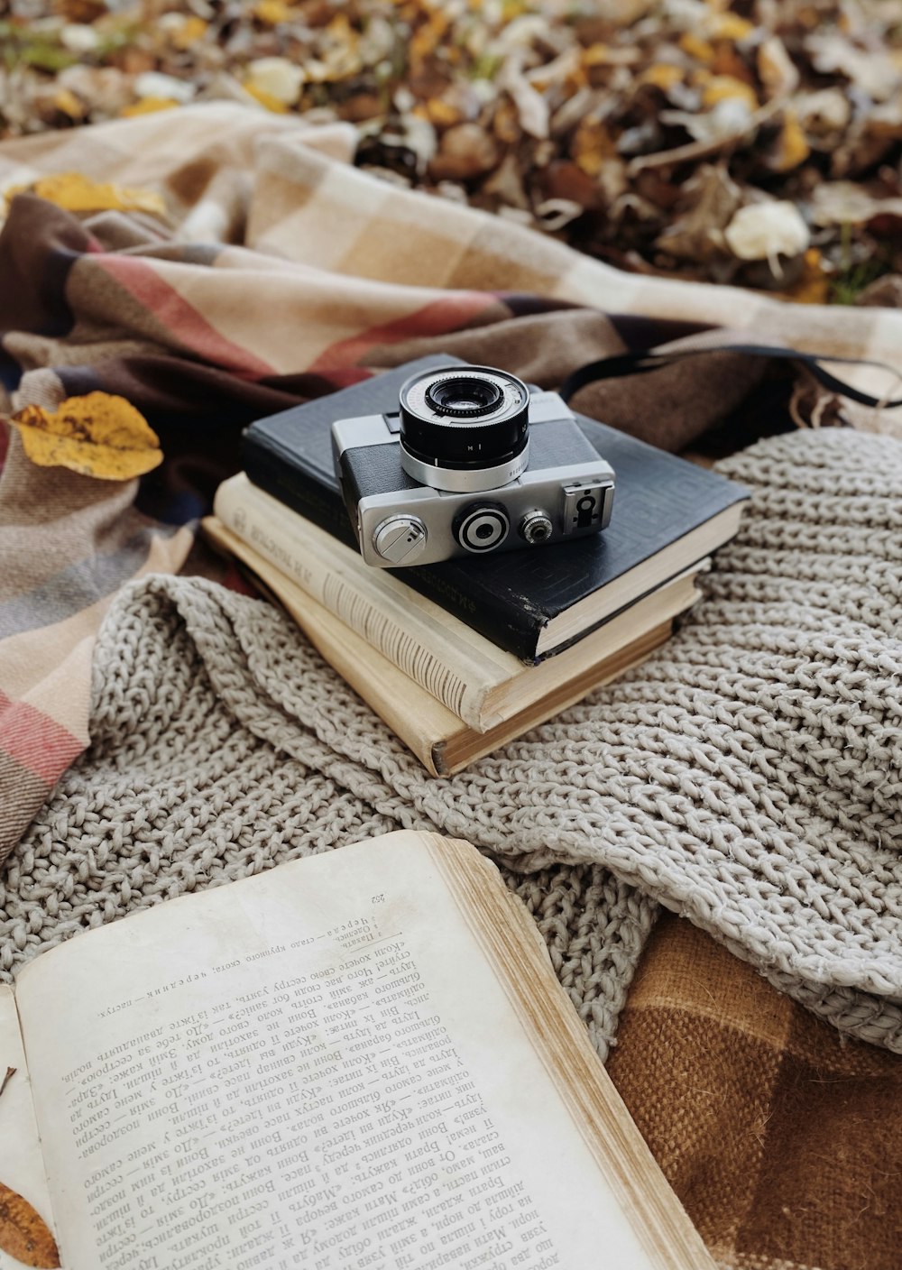 a book and a camera on a blanket