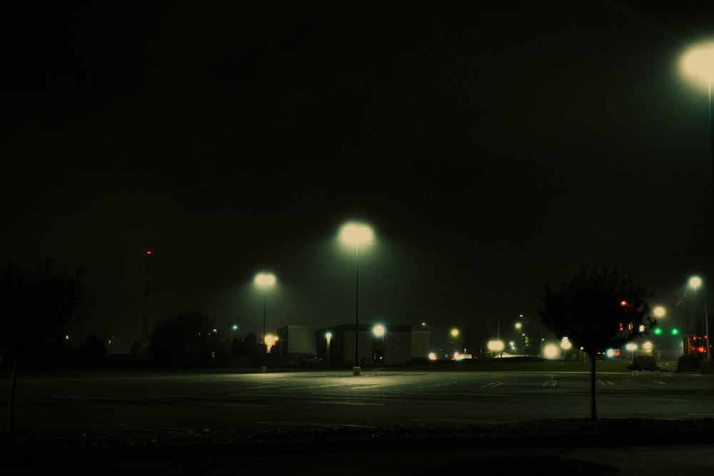 an empty parking lot at night with street lights