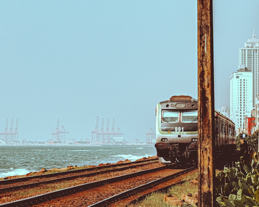 a train traveling down train tracks next to a body of water