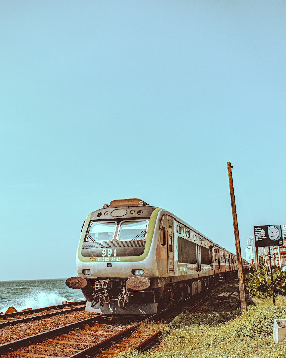 a train traveling down train tracks next to the ocean