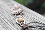 A close-up of a handcrafted jewelry piece on a wooden table.