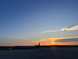 Cargo plane taking off at sunrise over an airport runway.