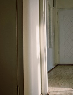 Elegant white painted wooden door with glass panels in a bright hallway