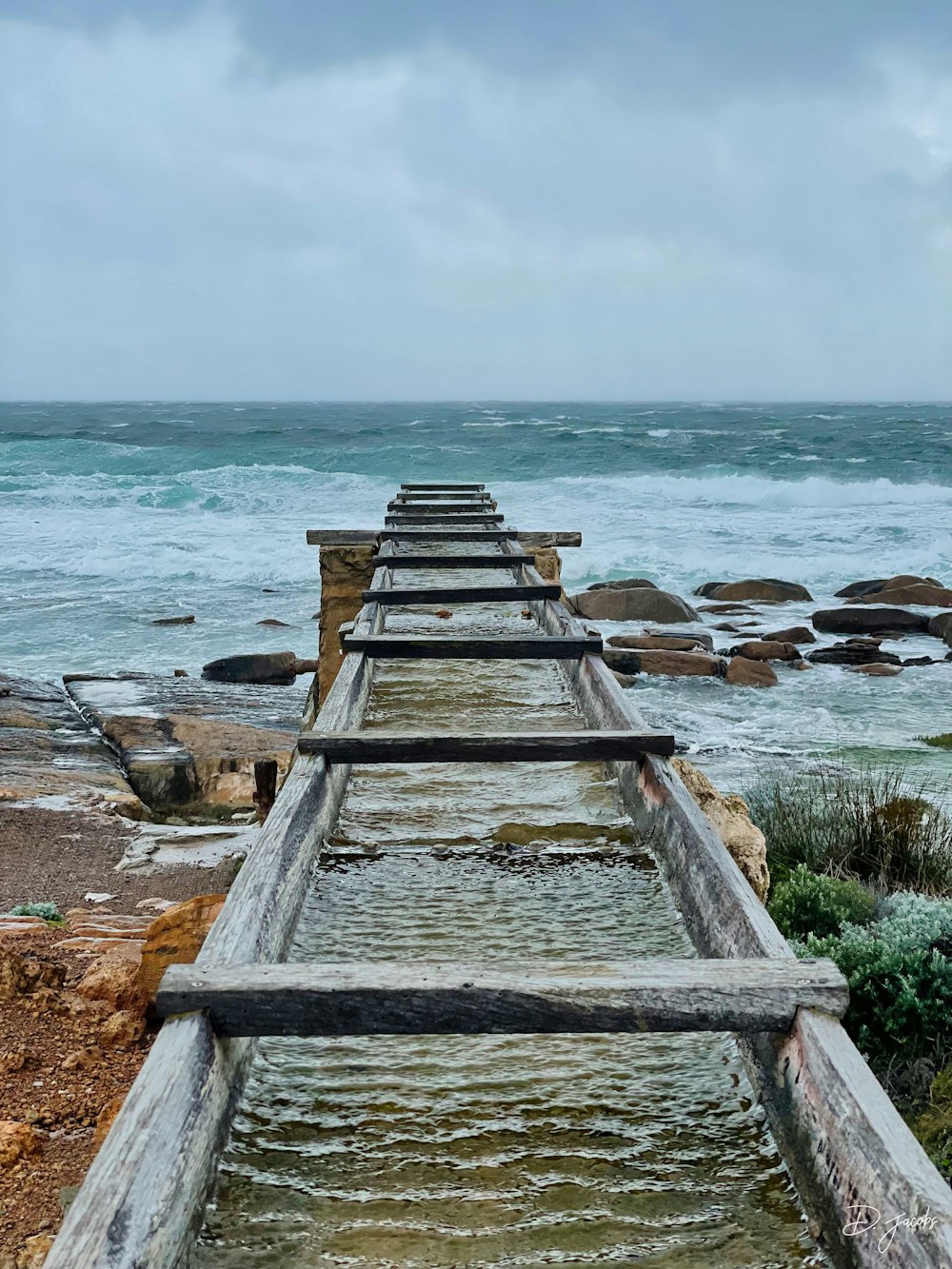 a row of wooden benches sitting on top of a beach