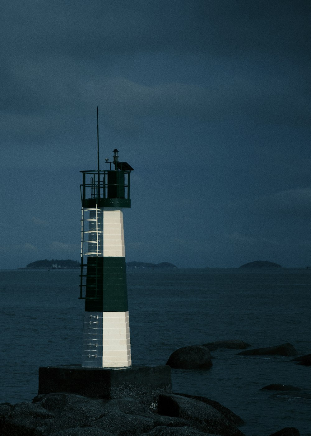 Ein Leuchtturm sitzt auf einem Felsen in der Nähe des Ozeans