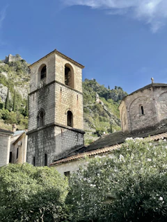 Ancient stone church tower surrounded by lush greenery in the heart of Portet-sur-Garonne.