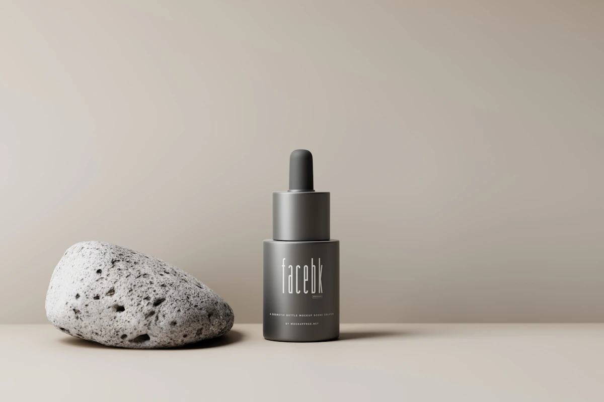 a bottle of liquid next to a rock