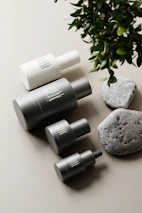 A minimalist flat lay of pawsure’s premium grooming bottles arranged on a beige background.