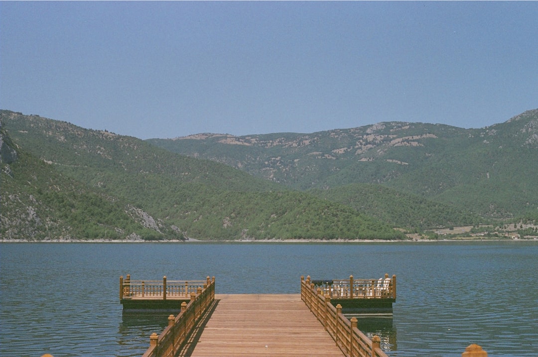 a dock on a lake with mountains in the background,
