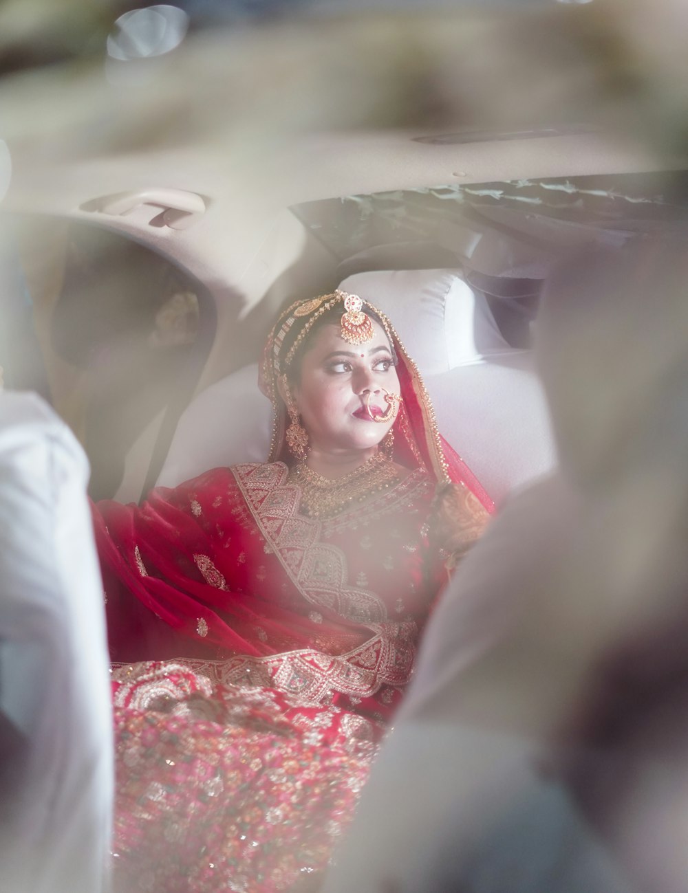 a woman in a red and white dress sitting in a car