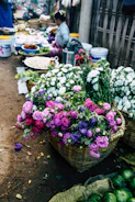 A lively market scene with fresh flowers and colorful produce.