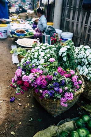 Colorful market scene showcasing fresh produce and flowers.