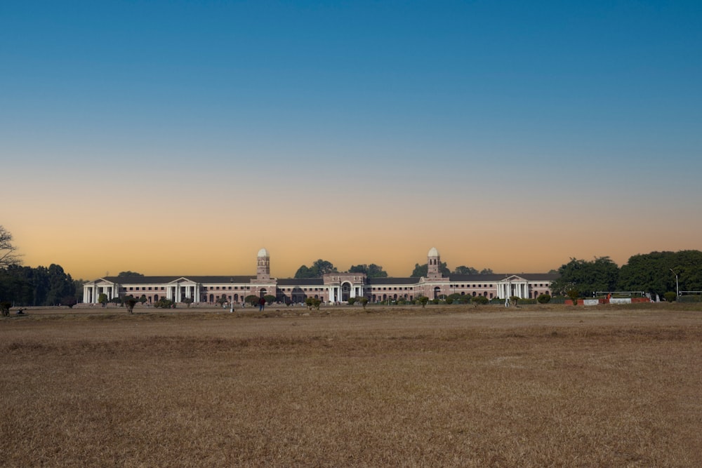 a large building in a field with trees in the background