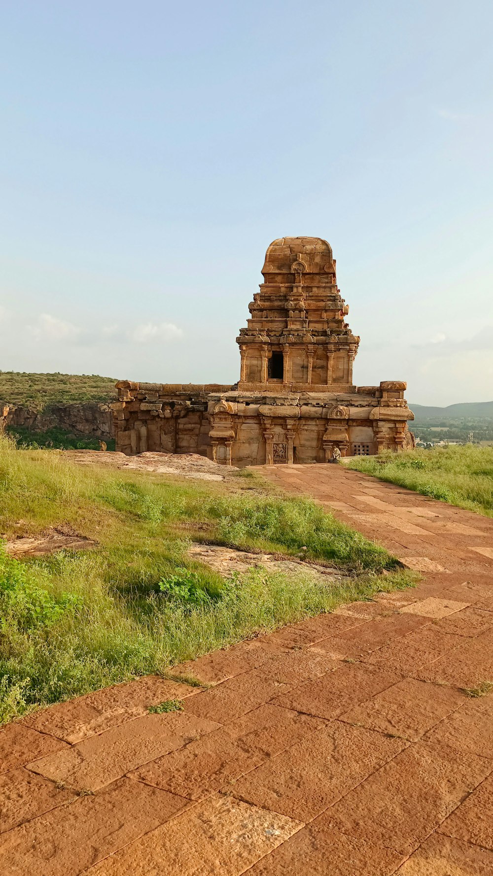 a large stone structure sitting on top of a lush green field