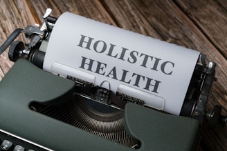 a close up of a typewriter with a paper that says holstic health