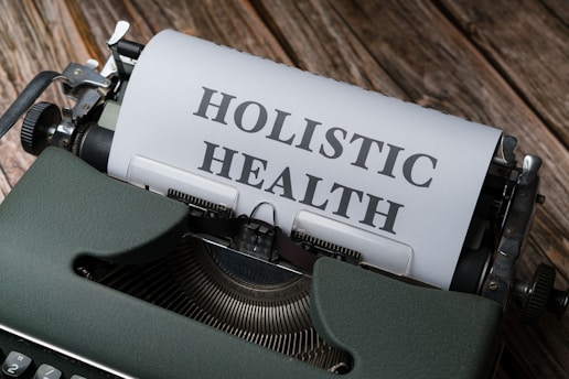 a close up of a typewriter with a paper that says holstic health