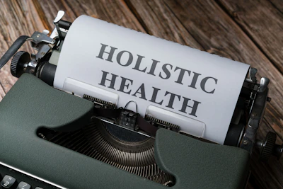 a close up of a typewriter with a paper that says holstic health