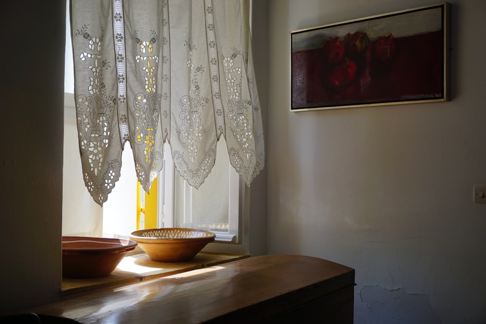 a bowl sitting on a table in front of a window