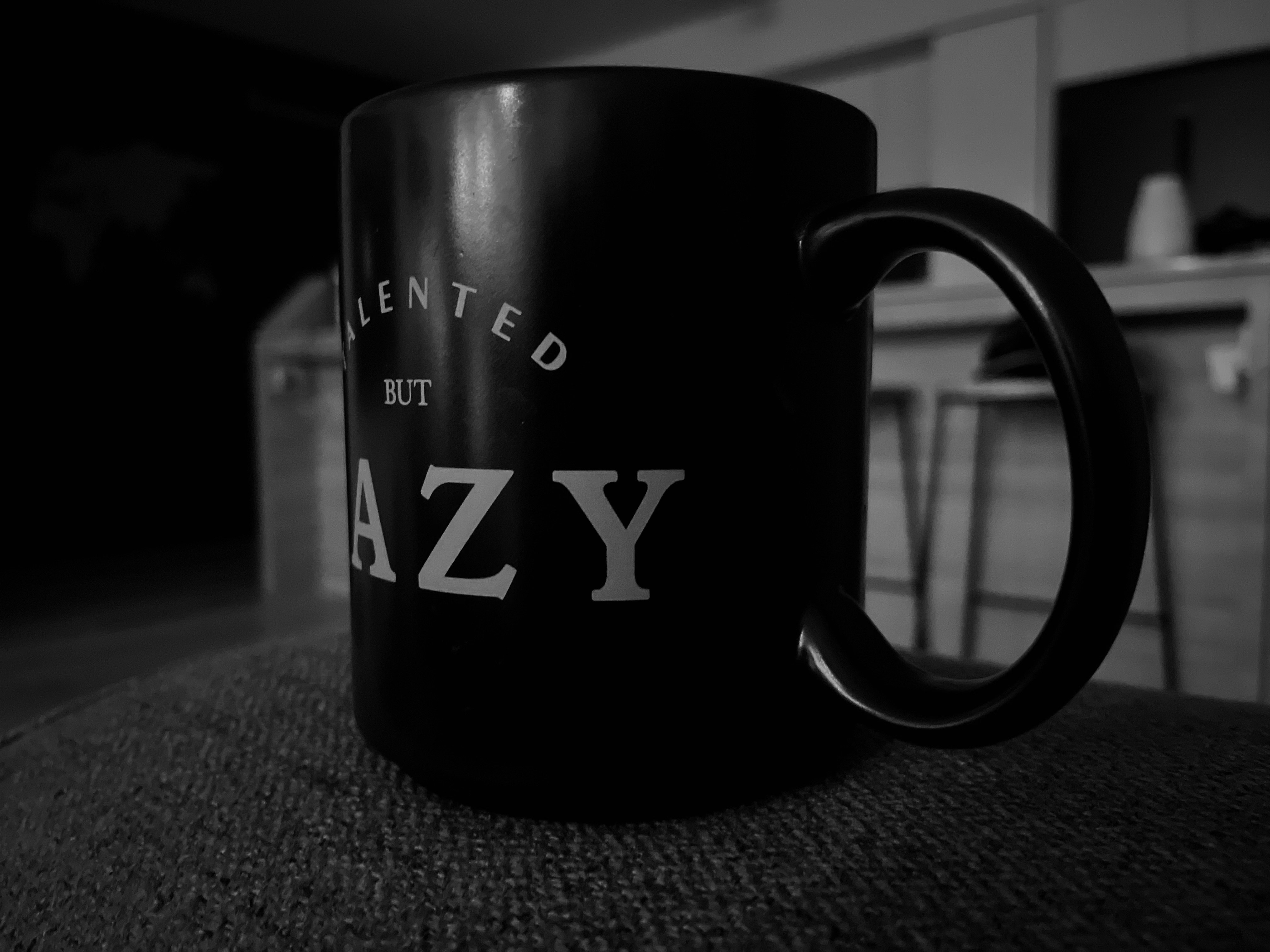 a black coffee mug sitting on top of a table