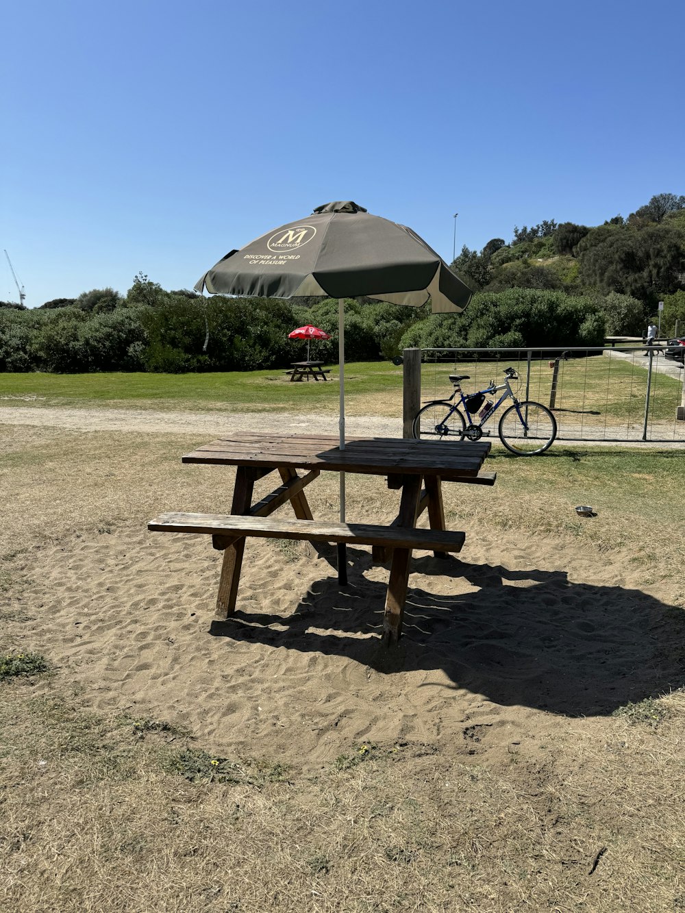 a picnic table with an umbrella in the background