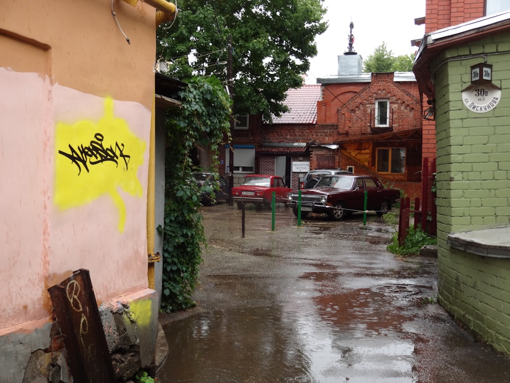 a wet street with cars parked on the side of it