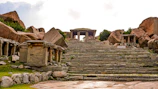 Weathered stone steps leading up to a mysterious ancient temple entrance.