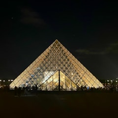 Corporate gathering held beneath a sleek pyramid tent with clear side panels.