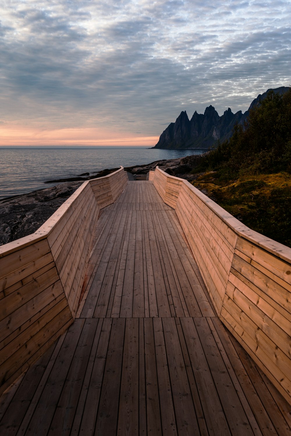 a wooden walkway next to a body of water
