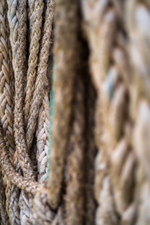 Close-up photo of natural fiber ropes neatly coiled on a wooden table.