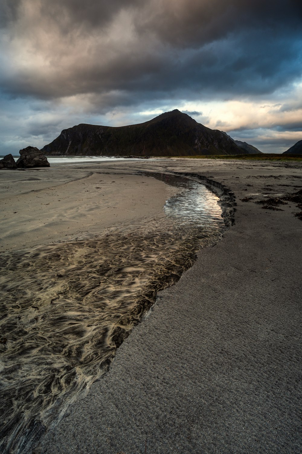 a body of water sitting on top of a sandy beach