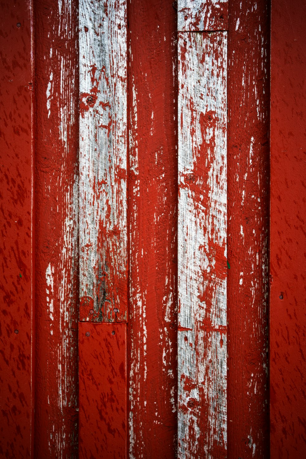 Un primer plano de una puerta roja con pintura blanca
