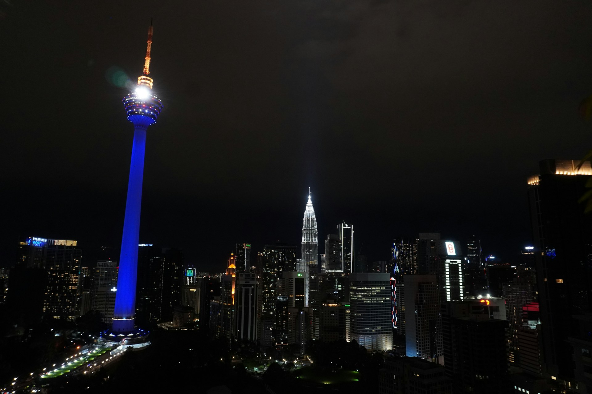 A dynamic cityscape at dusk illuminated by glowing 5G network signals weaving through skyscrapers, symbolizing advanced telecommunications infrastructure.