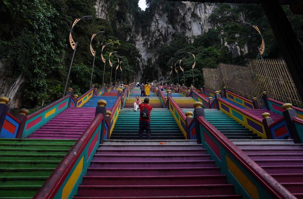 um homem em pé no topo de um conjunto de escadas coloridas