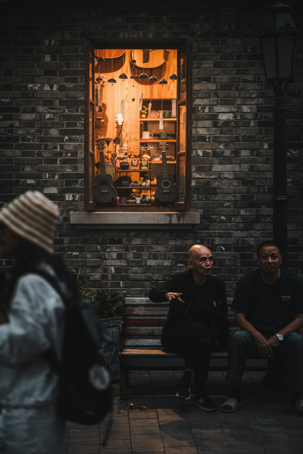 a group of people sitting on a bench in front of a window