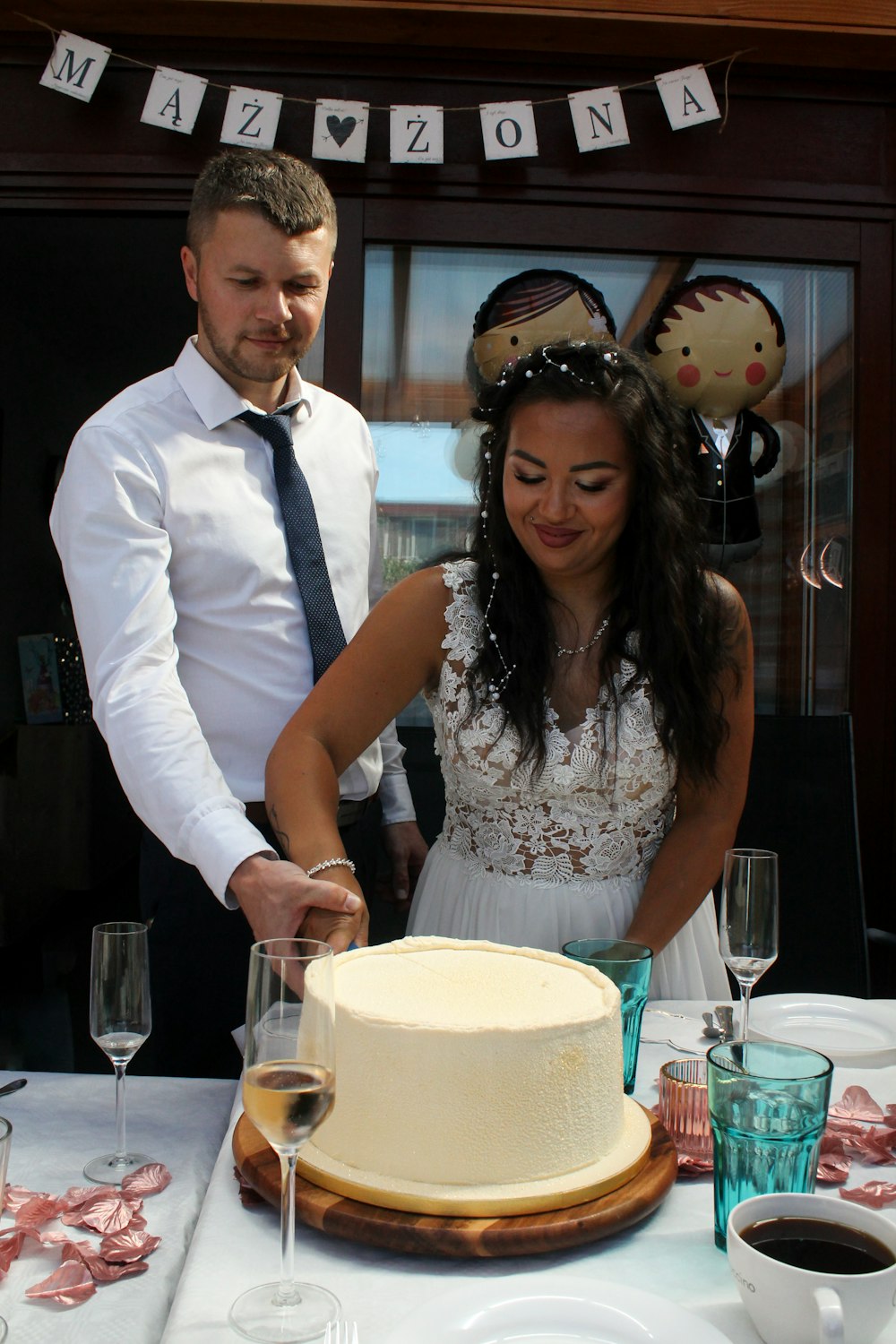 a man and a woman cutting a cake together