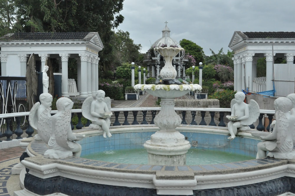 a fountain with statues around it in a park