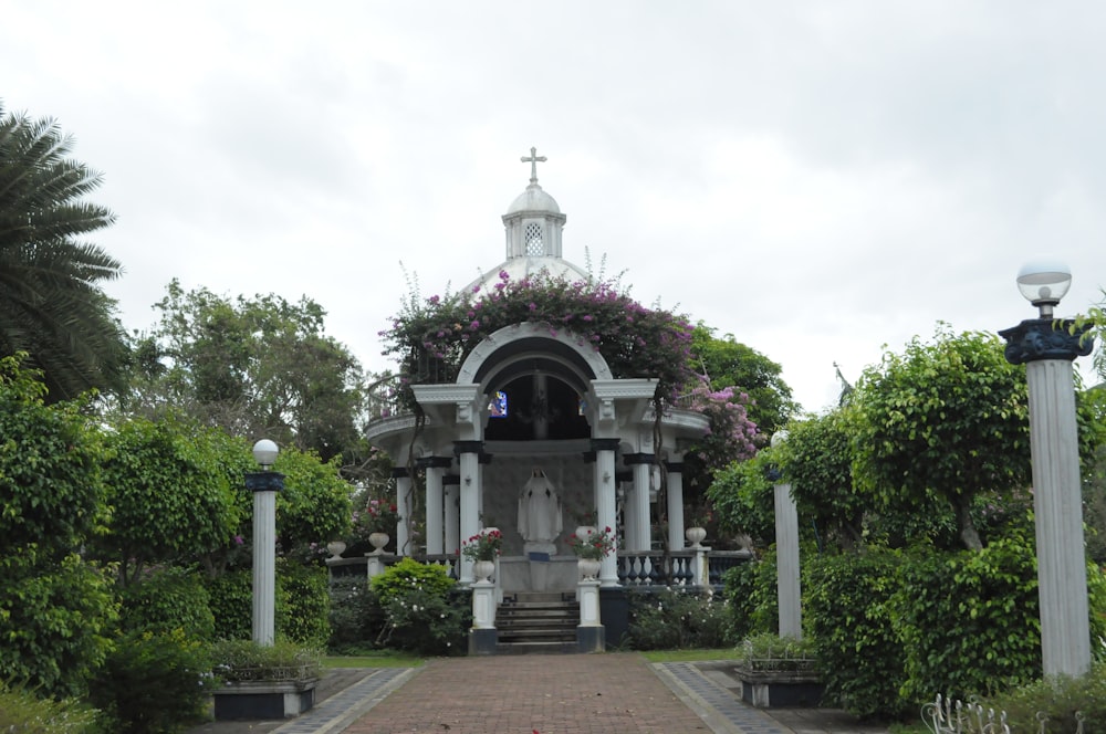 a small white church surrounded by greenery and trees