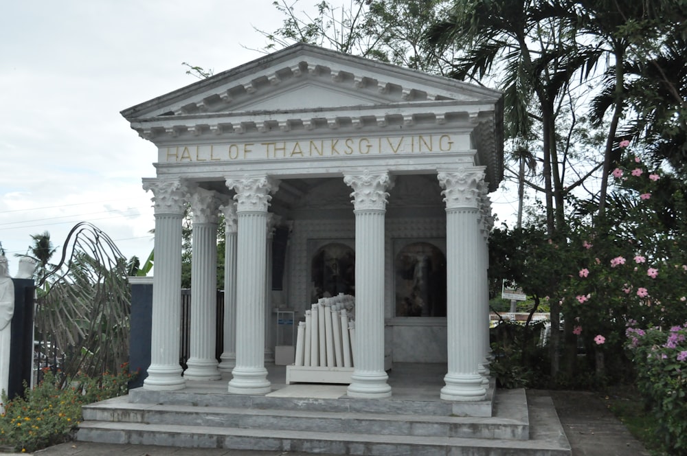 a small white building with pillars and pillars
