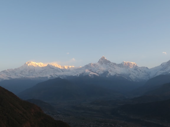 a mountain range with snow capped mountains in the distance