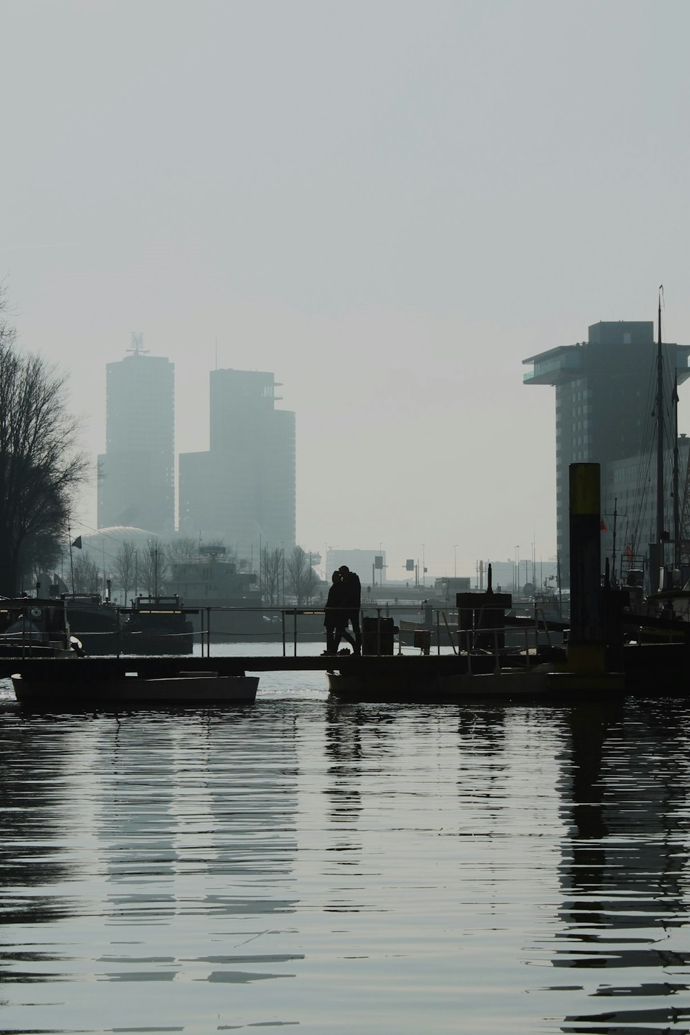 a man standing on a dock next to a body of water